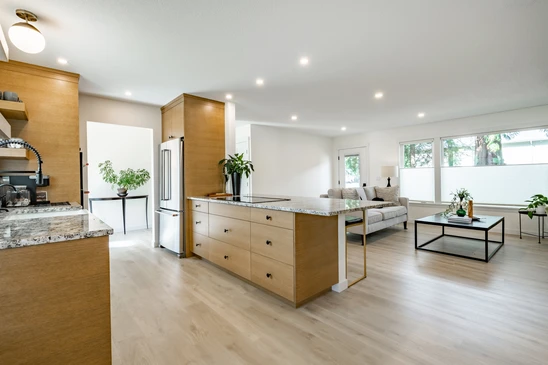 Ouvrier posant carrelage sur sol int&eacute;rieur, mains gant&eacute;es appliquant carreaux gris sur mortier-colle