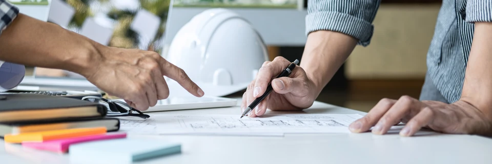 Deux artisans en salopettes travaillent dans une pièce en rénovation