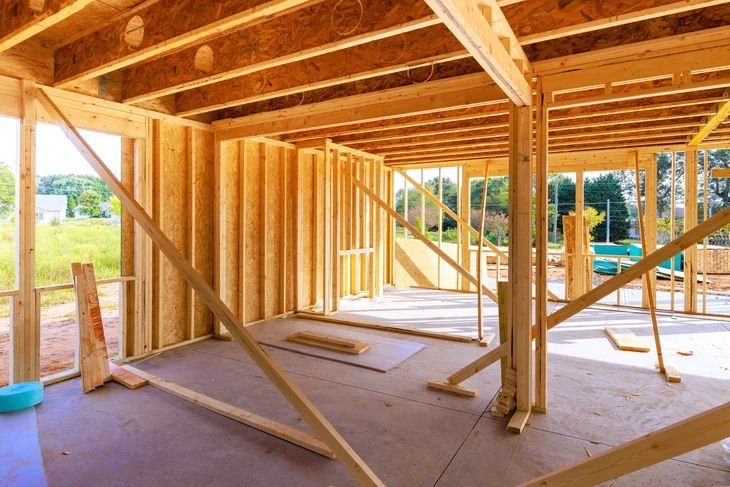Façade d'immeuble résidentiel moderne avec balcons et grandes baies vitrées sous ciel bleu dégagé