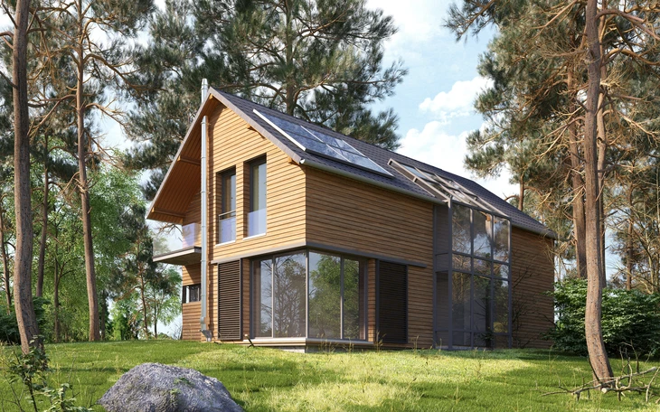 Maison écologique miniature recouverte de gazon avec panneaux solaires photovoltaïques sur toiture, située dans paysage verdoyant avec arbre et oiseau en vol