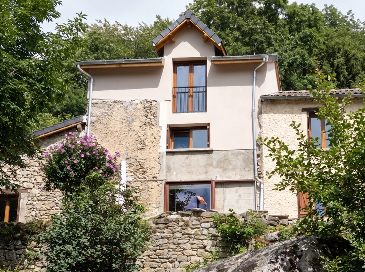 Façade d'immeuble résidentiel moderne avec balcons et grandes baies vitrées sous ciel bleu dégagé